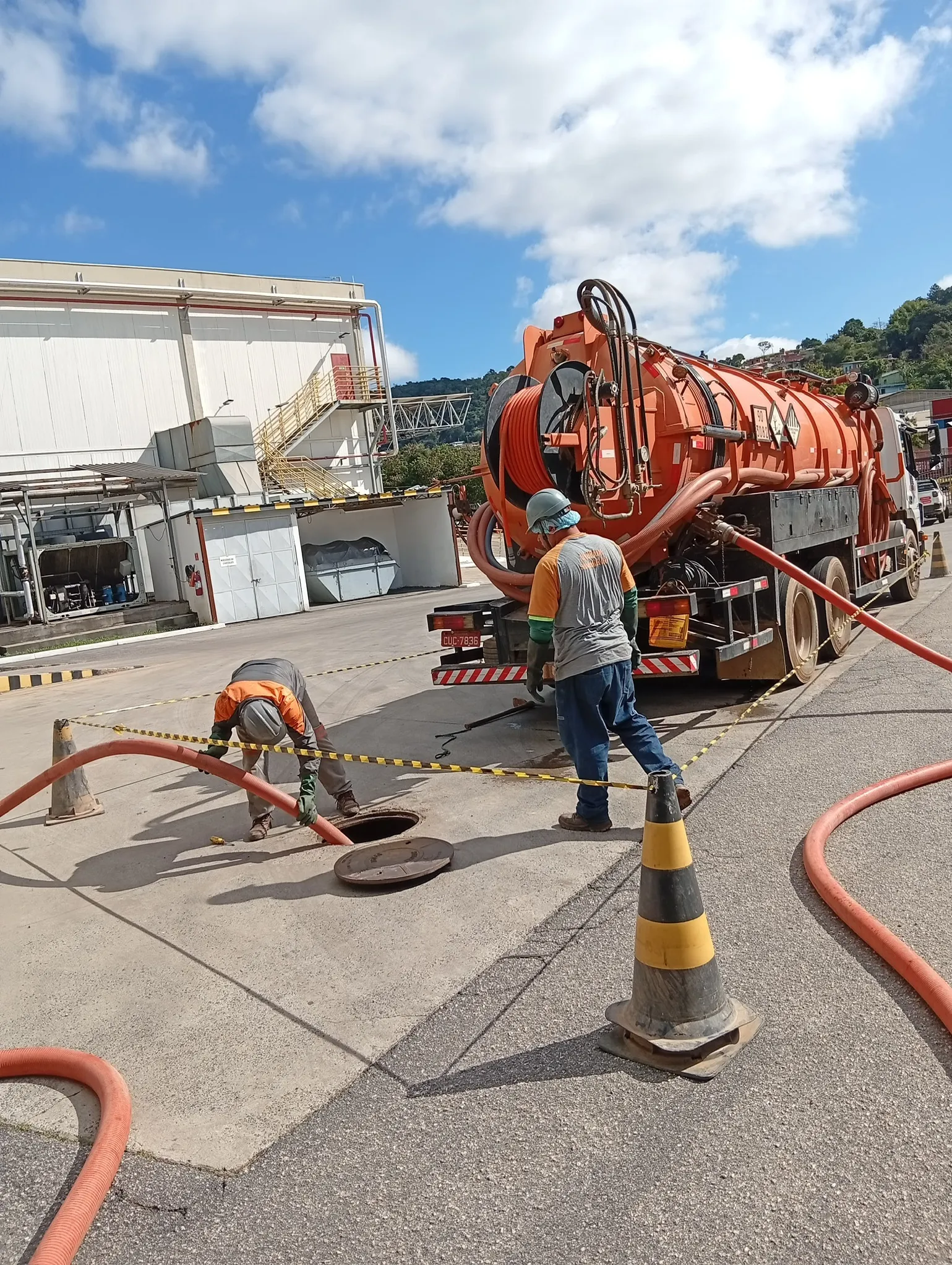 Equipe realizando limpa fossa em poço de visita